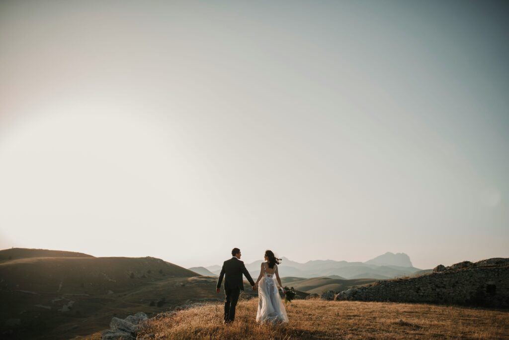 A couple posing for a wedding photoshoot, with a photographer capturing the moment.